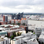 Luftaufnahme des Hamburger Hafens mit Blick auf die Elbphilharmonie und die Speicherstadt.