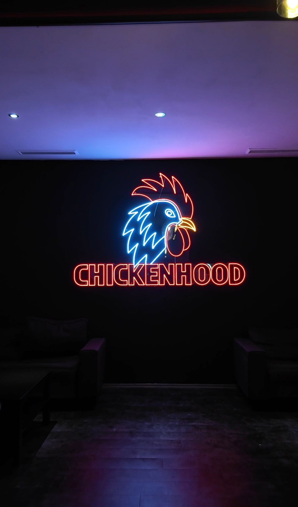 Leuchtendes Neon-Logo von Chickenhood an der Wand im Standort Datteln