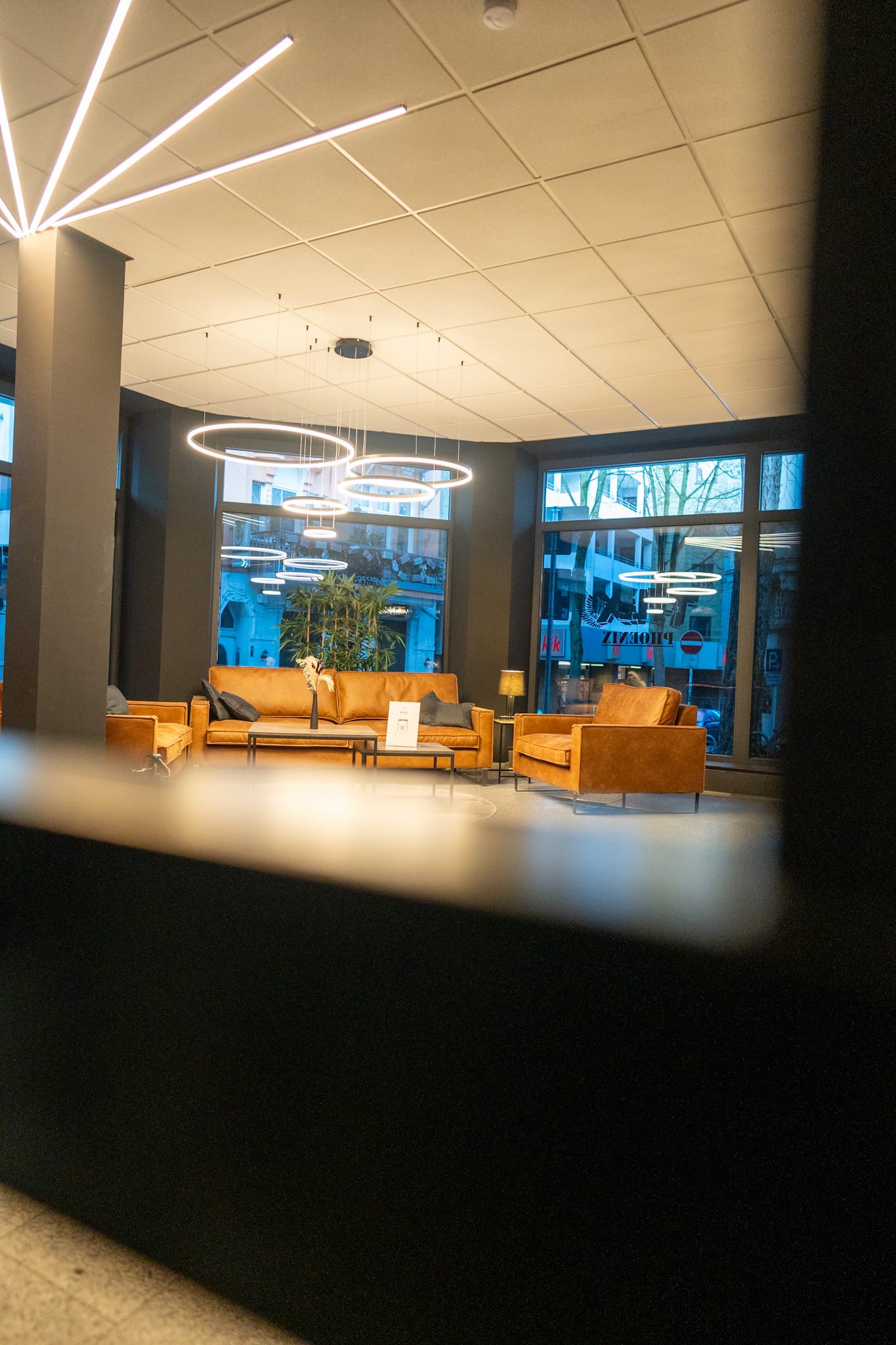 Heller Loungebereich mit Ledersofas und modernen Lampen im T-Flex Fitnessstudio Dortmund