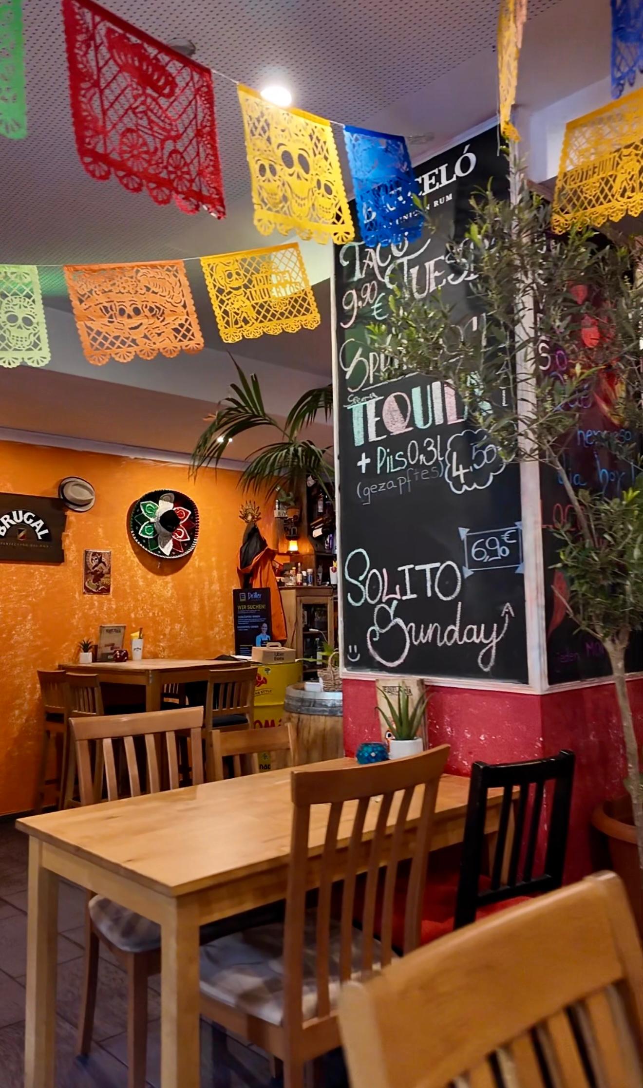 Bunt dekorierter Innenbereich mit Kreidetafel und Holzstühlen im Tequilaria Bochum