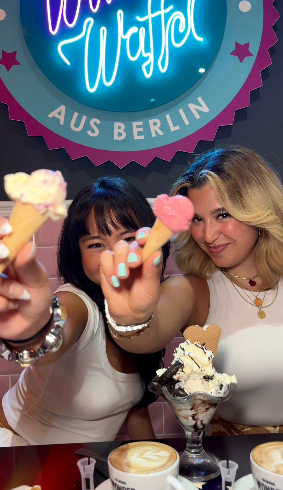 Zwei Frauen halten Mini-Eiswaffeln fröhlich in die Kamera bei Wonderwaffel Dortmund
