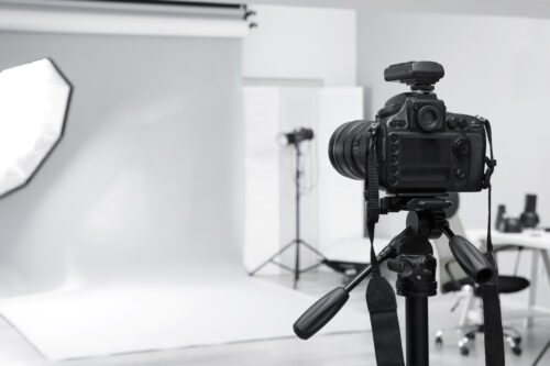 Kamera auf Stativ im professionellen Fotostudio mit weißem Hintergrund