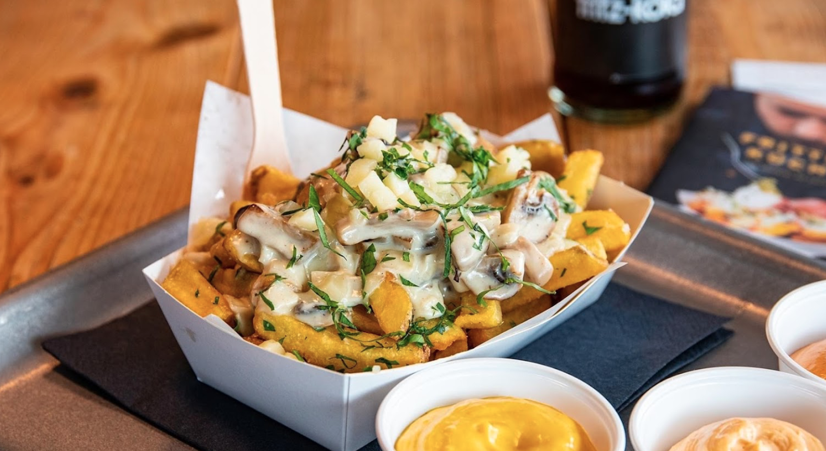 Frische Pommes mit Pilzrahmsoße, Käse und Kräutern in einer Schale – serviert in der Frittenküche Dortmund
