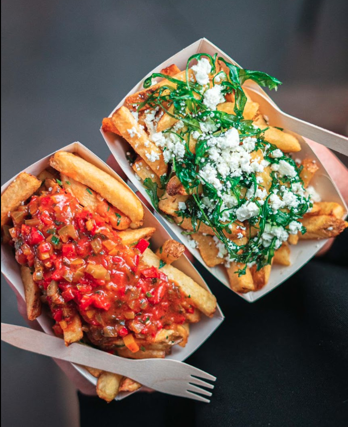 Zwei Portionen Pommes mit verschiedenen Toppings wie Hackfleischsoße, Rucola und Feta in der Frittenküche Dortmund