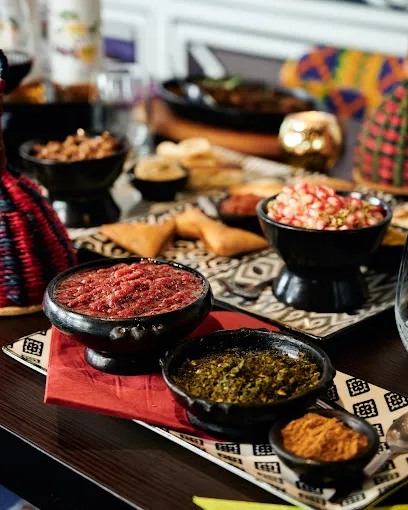 Bunte afrikanische Vorspeisenplatte im African Violet Frankfurt mit Dips, Samosas, gerösteten Erdnüssen und traditionellen Mustern
