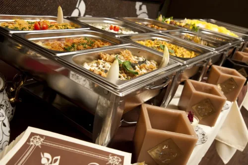 Buffet im Djadoo Restaurant Darmstadt mit einer Auswahl an orientalischen Spezialitäten, darunter Reisgerichte, Eintöpfe, Salate und Dips in Warmhaltebehältern