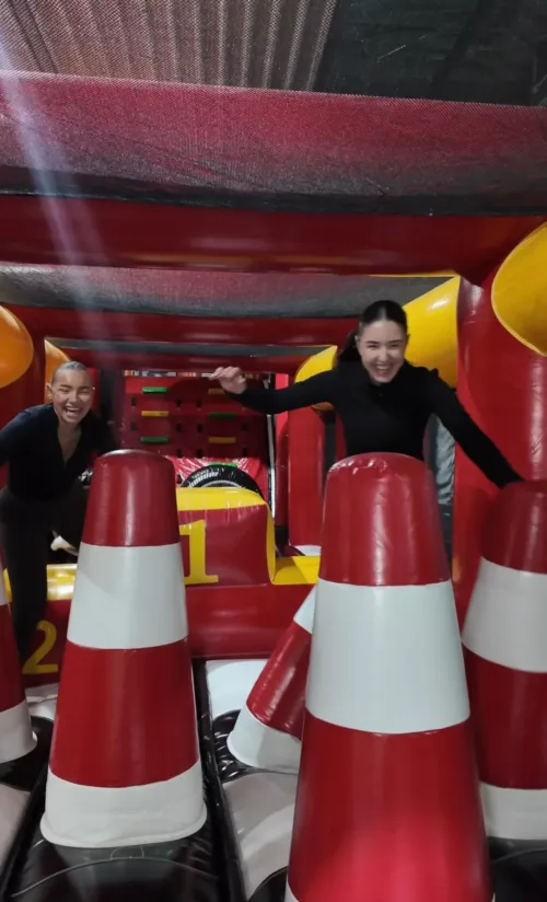 Zwei Frauen durchqueren lachend einen Parcours mit großen rot-weißen Spielkegeln im FunFusion Wetzlar – bunte Action in der Indoor-Arena