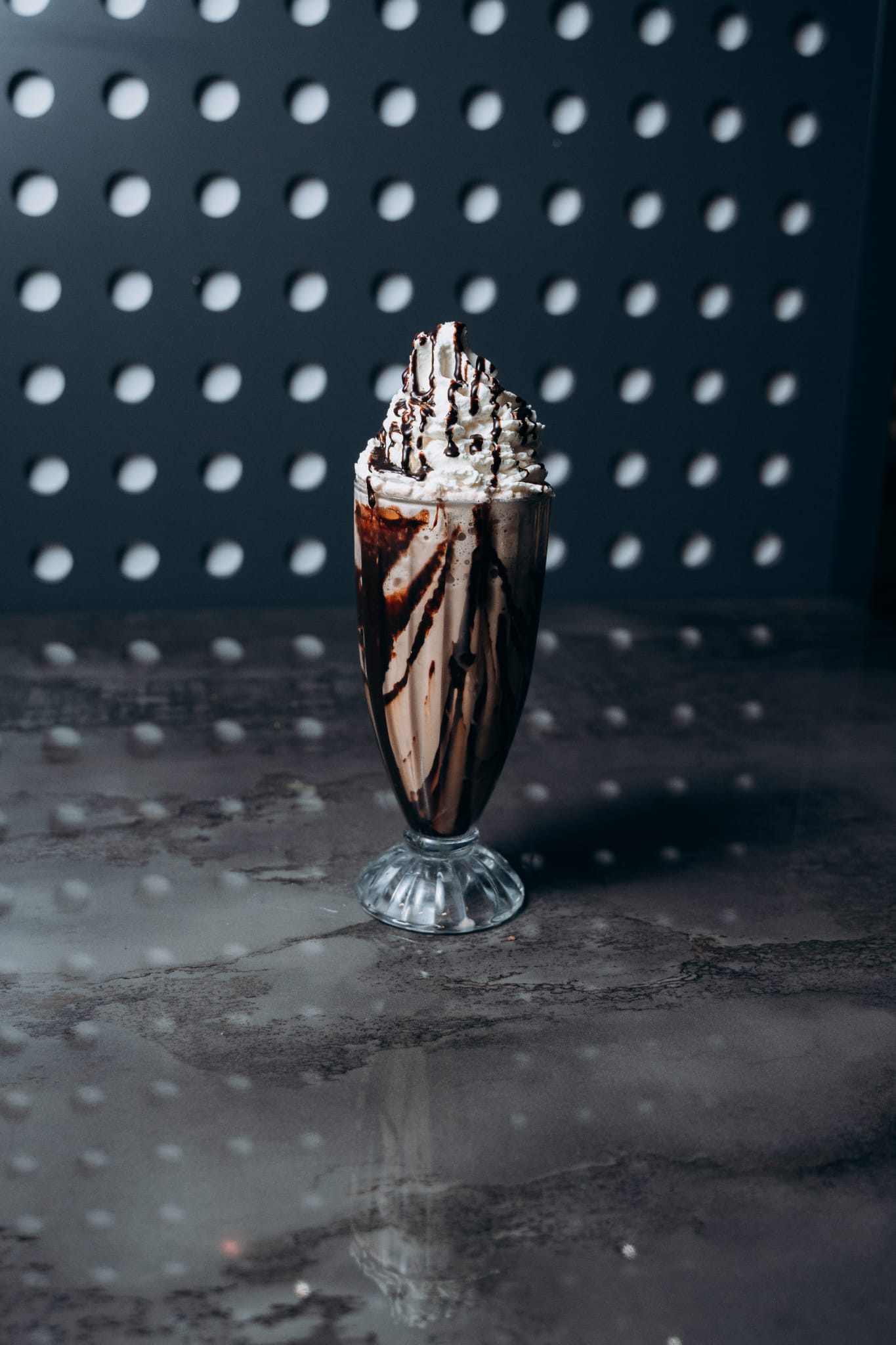 Hoher Schokoladen-Milchshake im Glas mit viel Sahne und Schokosauce, serviert im modernen Ambiente von Shiva Food and More Dinslaken