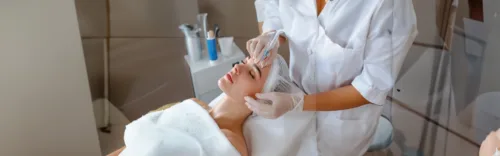 Frau erhält eine Aquafacial-Behandlung im Kosmetikstudio durch Fachpersonal