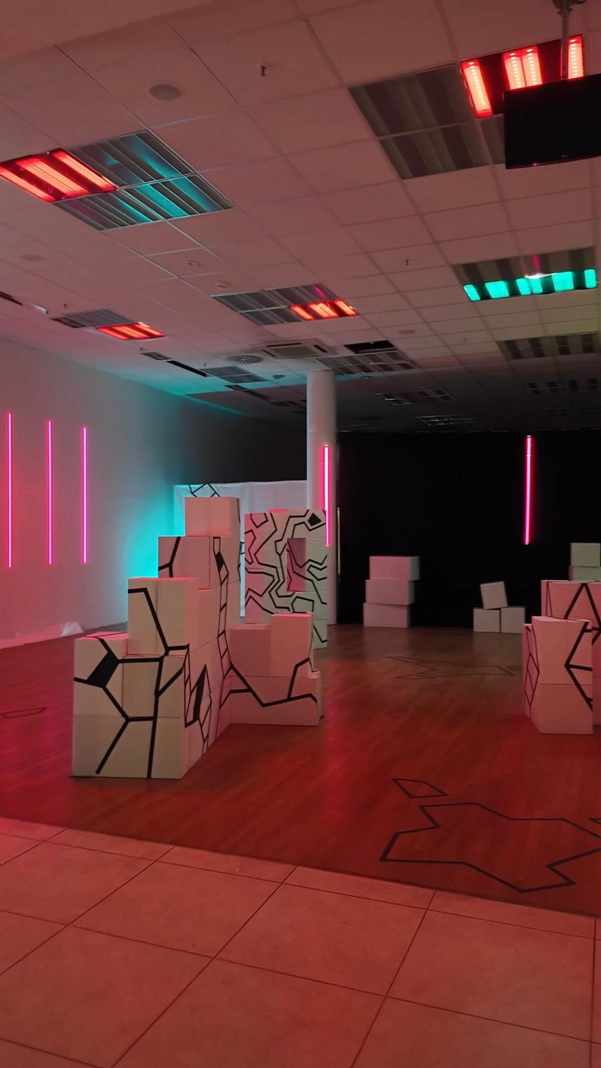 Beleuchtete VR-Arena in Berlin mit geometrischen Hindernissen und futurativem Design