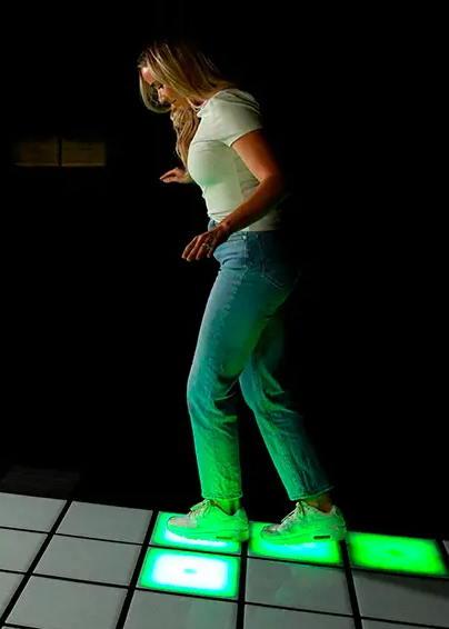 Frau spielt auf leuchtenden Flashpads bei Escape Adventure Frankfurt