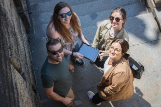 Gruppe junger Erwachsener mit Tablet beim Outdoor Escape Game „Operation Mindfall“ von Frankfurt Secrets