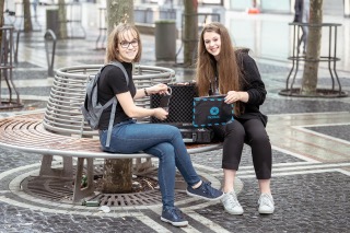 Zwei junge Frauen mit Escape-Game-Koffer von „Operation Mindfall“ bei Frankfurt Secrets