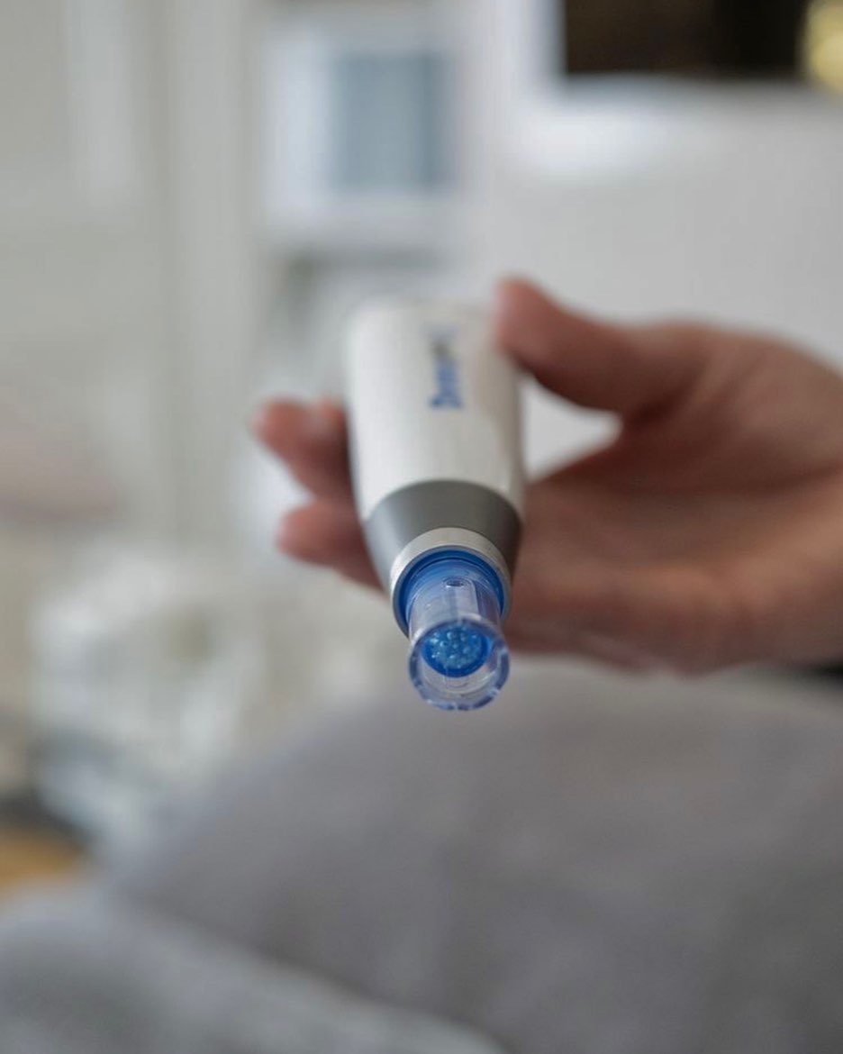 Hand hält einen Dermapen zur kosmetischen Hautbehandlung