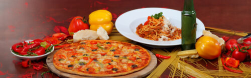 Frische Pizza mit Gemüse und ein Teller Spaghetti im Pizza Paradies Köln