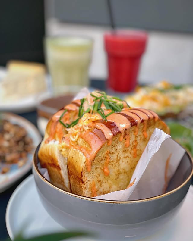 Frisch getoastetes Eggdrop Sandwich mit cremigem Topping und Frühlingszwiebeln im Brunch-Café 9 TO 5 Berlin