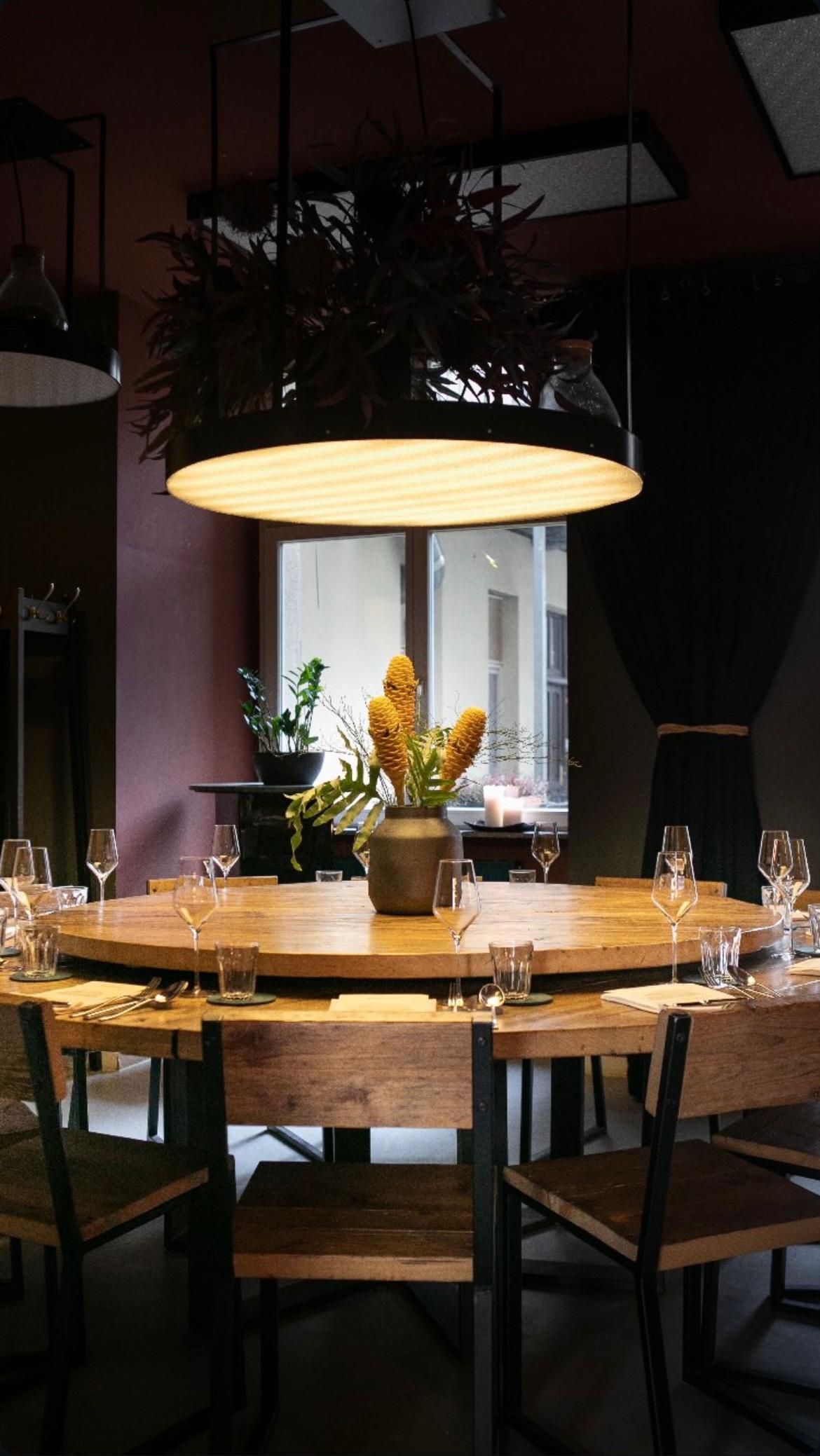 Stilvoll gedeckter großer Holztisch im Bonvivant Cocktail Bistro Berlin