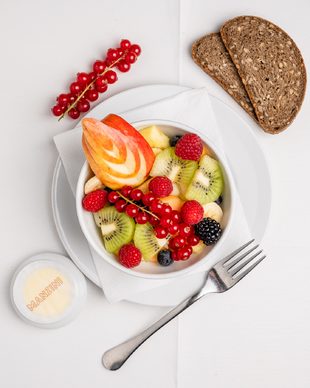 Frischer Obstsalat mit Vollkornbrot im Café Restaurant Manzini in Berlin