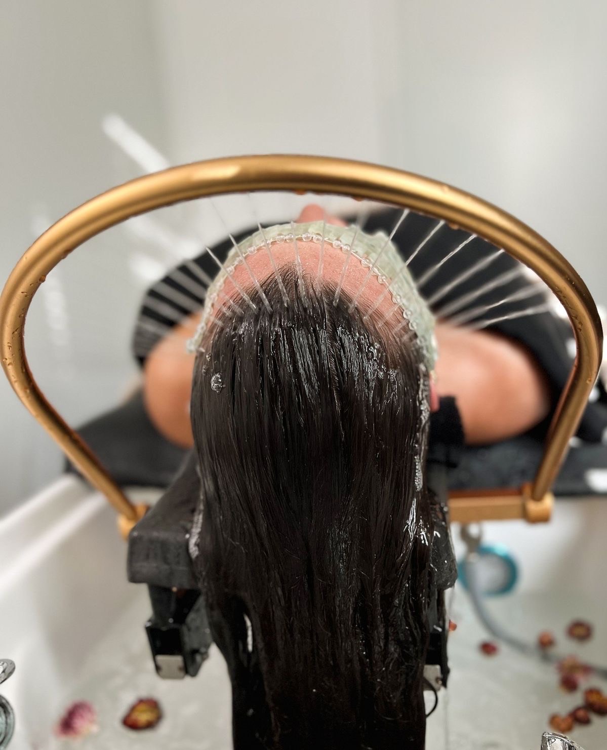 Rückansicht einer Frau mit nassem Haar während einer Wasseranwendung im Head Spa in Essen