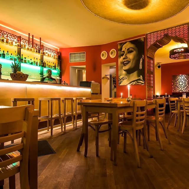 Stilvoll eingerichtetes indisches Restaurant Meena Kumari in Berlin mit warmem Licht und Bar