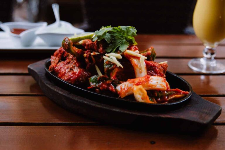 Würzige Vorspeise auf heißer Platte mit frischen Kräutern im Meena Kumari Berlin als Teil eines 3-Gänge-Menüs