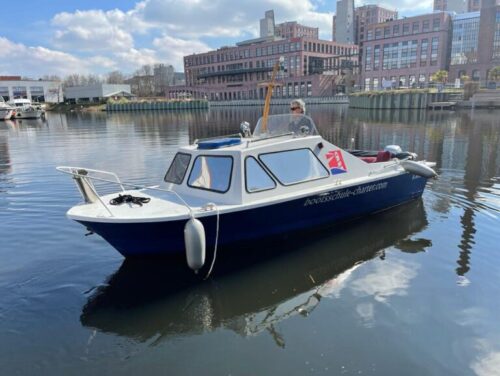 Charterboot der Bootsschule und Charter Berlin vor moderner Kulisse auf dem Wasser