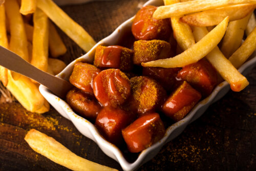 Frisch servierte Currywurst mit Pommes in klassischer Schale