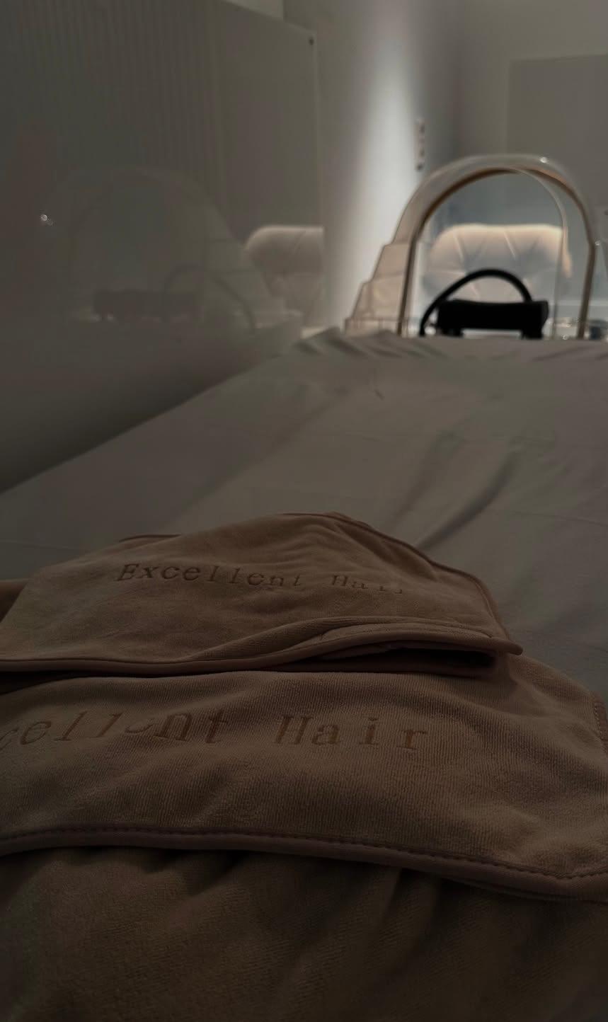 Nahaufnahme einer Liege mit Decke im Behandlungsbereich von Excellent Hair Wiesbaden