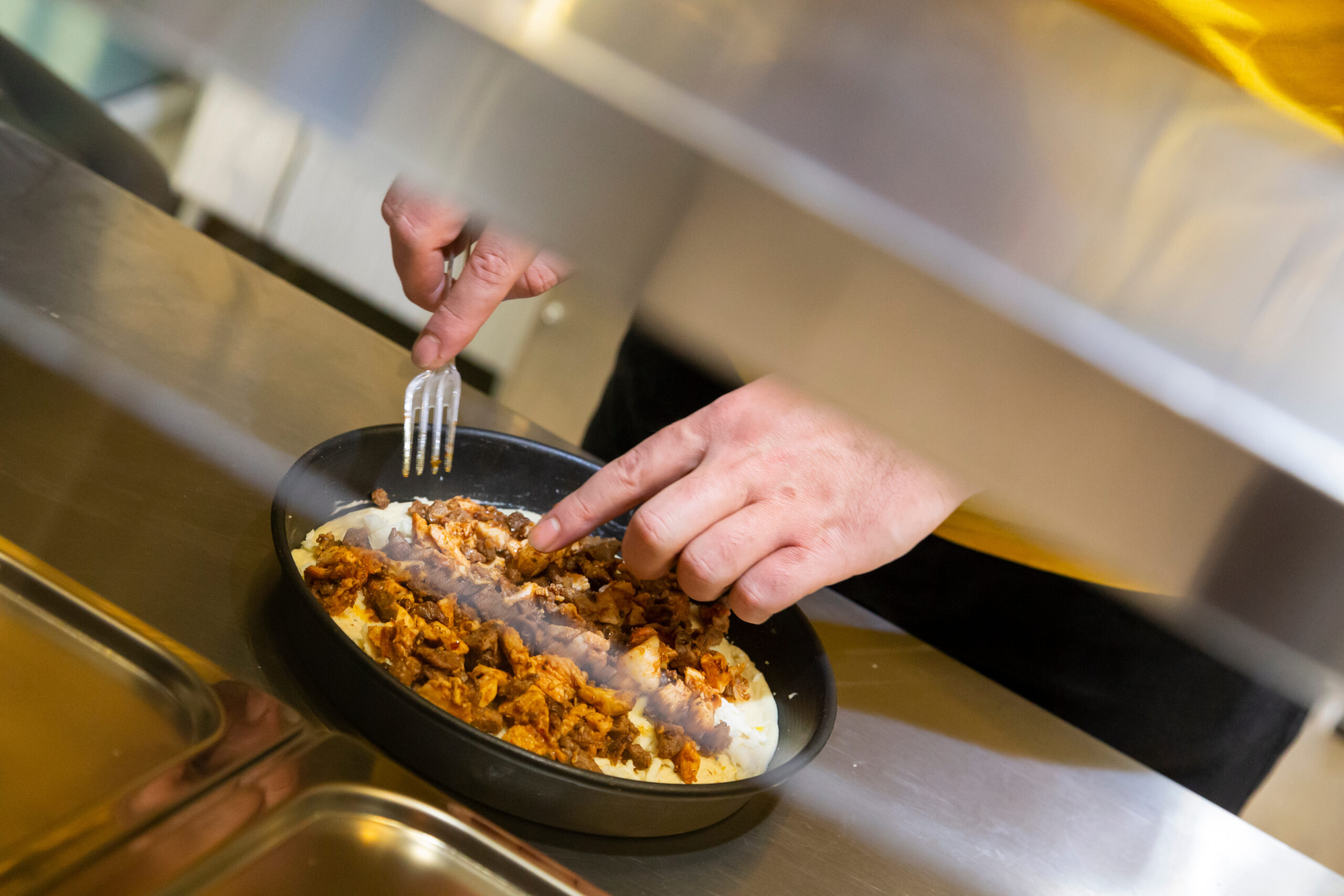 Frische Zubereitung einer Pizza bei Pan Pizza 2Go mit herzhaften Zutaten