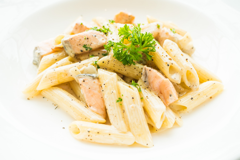 Penne mit Lachs in cremiger Sahnesauce, serviert bei Pizzaria Daily To Go in Düsseldorf